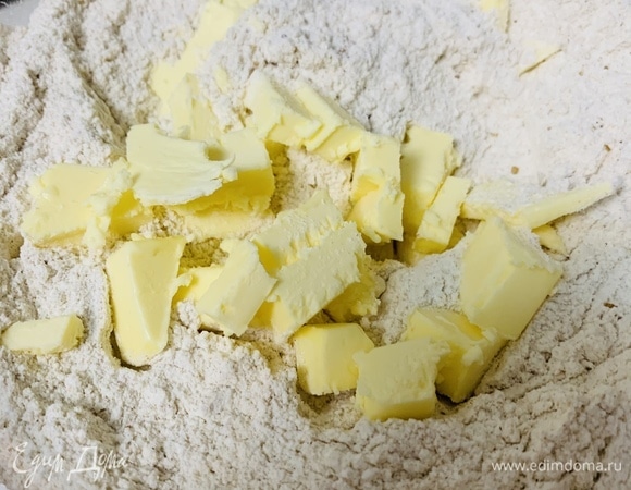 Нарезаем охлажденное сливочное масло мелкими квадратиками, добавляем к муке.