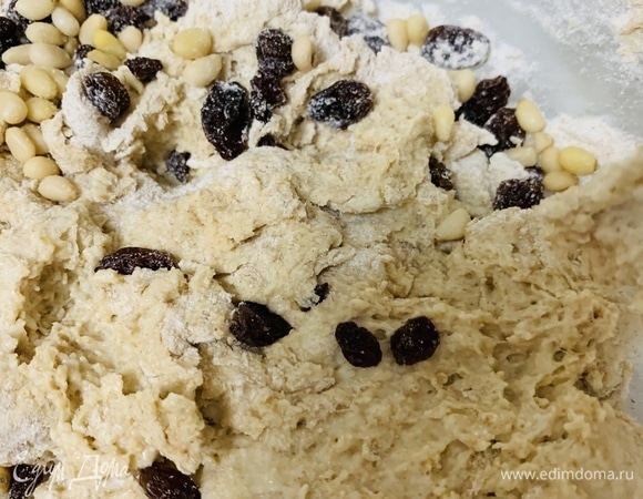 Делим смесь на две части. В одну добавляем изюм и орешки (по желанию можно использовать любые сухофрукты, семечки, вяленые помидоры, оливки и ароматные травы), а другую оставляем без добавок.