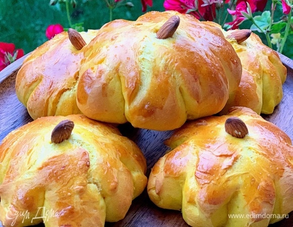 Смазываем булочки яйцом. В серединке делаем углубление и вставляем орешек, это будет черешок тыквы. Выпекаем булочки при 180°C до румяного цвета.