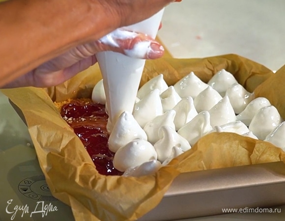 Готовый корж покрыть тонким слоем клубничного варенья, сверху украсить взбитыми белками из кондитерского мешка и вернуть пудинг в духовку еще на 20 минут.