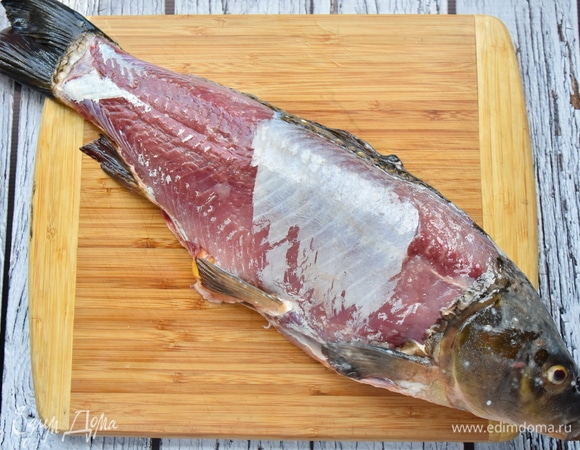 Карпа выпотрошить, удалить внутренности, жабры и чешую. Промыть и промокнуть бумажным полотенцем. С одной стороны удалить слой кожи. Посолить и сбрызнуть растительным маслом. Внутрь брюшка рыбы уложить веточки розмарина.