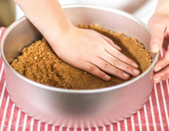 Смазать форму сливочным маслом (я использовала силиконовую форму). Распределить массу с печеньем по дну (толщина около 2 см), сделать бортик. Поставить в духовку и выпекать при 180°C около 15 минут. Дать коржу остыть 10–15 минут.