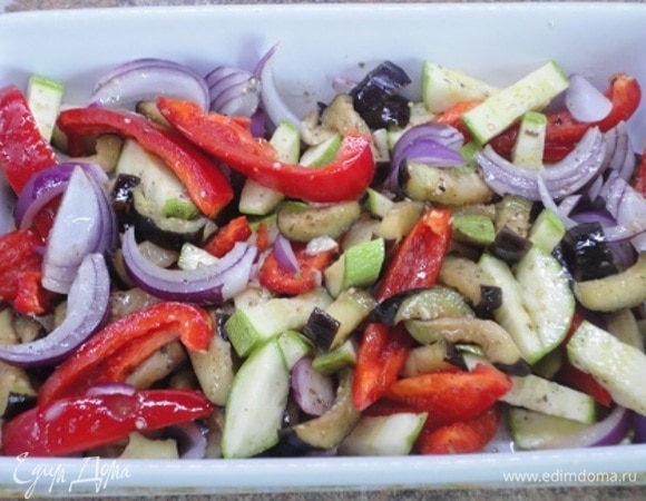 Овощи выложить в большую форму для запекания практически в один слой, посолить по вкусу, залить заправкой и перемешать. Запекать 20 минут при 220°C. Овощи должны стать мягкими. Посыпать овощи сыром и печь еще 20–25 минут, пока они не подрумянятся и не пропекутся.