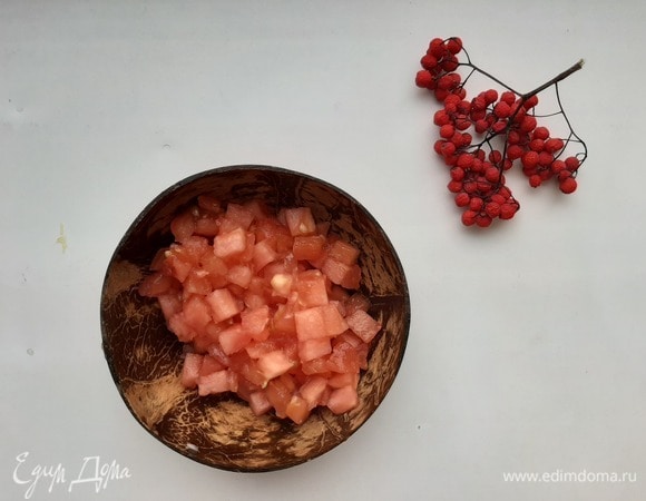 На верхушке помидора сделать надрез крест-накрест и залить его кипятком на несколько минут. Аккуратно снять кожицу и удалить плодоножку, нарезать небольшими кубиками и добавить в зажарку. Тушить под крышкой 10 минут.