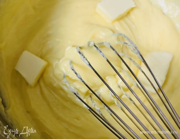 Всю массу возвращаем на небольшой огонь и при постоянном взбивании венчиком доводим до загустения. Как только появляются первые пузырьки, снимаем крем с огня. К теплому крему добавляем масло и взбиваем до однородной консистенции.