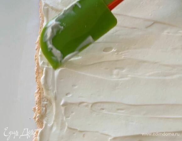 Распределите крем лопаткой по всей поверхности меренги. На край, к которому будете сворачивать, нанесите чуть меньше крема, чтобы рулет аккуратно свернулся. Оставьте 2–3 столовые ложки крема для украшения (прикрепления ягод) по желанию.