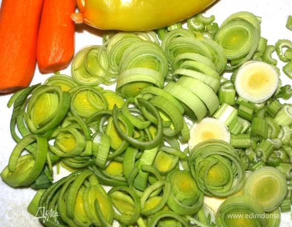 Маш промыть, залить 1,5 л воды и варить до готовности. Маш готовится 40–50 минут. Пока он варится, можно приготовить овощи. Лук-порей, сельдерей и чеснок порубить. Морковь очистить. Болгарский перец очистить от плодоножки, семян и перегородок. Зелень порубить.