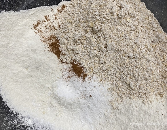 Овсяные хлопья измельчить в блендере до состояния мелкой крупы. Муку просеять, добавить измельченные хлопья, соль, соду, разрыхлитель и корицу, венчиком перемешать до однородности.