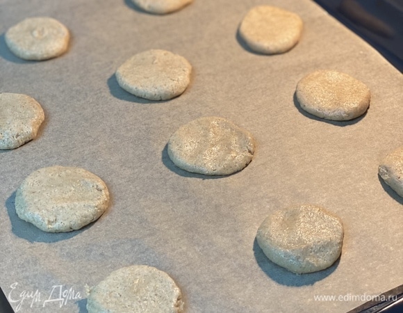 Духовку разогреть до 180°C, режим «верх-низ». Противень застелить пергаментом, из теста скатать шарики, приплюснуть их и разложить на расстоянии друг от друга, выпекать не более 15 минут.