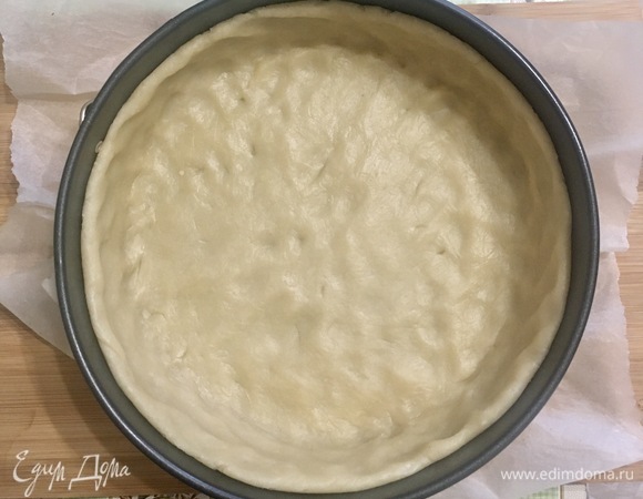Достаем тесто, раскатываем его толщиной примерно 5–8 мм, укладываем в форму диаметр 24 см. Если форма металлическая, то дно застелить пергаментом. Убираем на 30 минут в морозилку. После этого выпекаем при 170°C сначала 15 минут под грузом, потом еще минут 15 без груза.