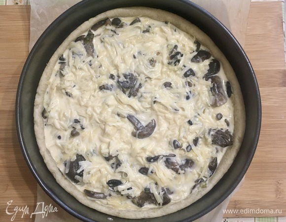 В готовую основу выкладываем натертый сыр, обжаренные грибы и заливку.
