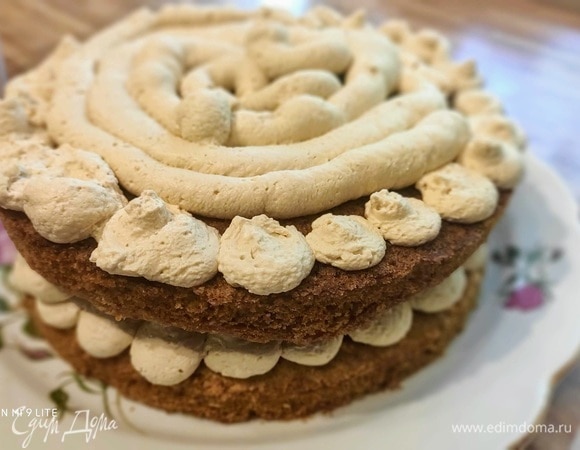 Заполнить кремом кондитерский мешок с круглой насадкой. Положить первый корж на блюдо и нанести крем. Я по краям нанесла крем в виде башенок, так будет интереснее смотреться в готовом виде. Я собираюсь оставить торт «голым», то есть без кремового слоя с внешней стороны. Осторожно положите сверху следующий корж и слегка прижмите, затем — снова слой крема. В завершение нанесите слой крема в виде башенок.