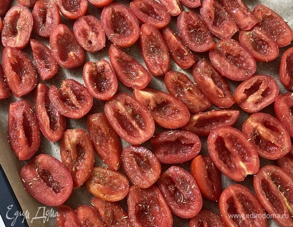 Духовку разогреть до 90°C. Режим конвекции — это важно! Противень застелить пергаментом и разложить в один ряд половинки помидоров. Обильно посыпать смесью приправ, сбрызнуть оливковым маслом.