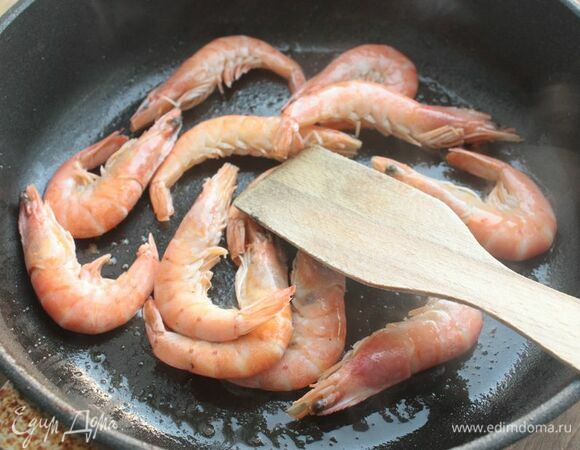Пока варится суп, обжарьте креветки до готовности на оливковом масле. Если хочется большей яркости вкуса, можно к готовым креветкам, снятым с огня, добавить еще мелко натертой апельсиновой цедры — получается очень интересно!