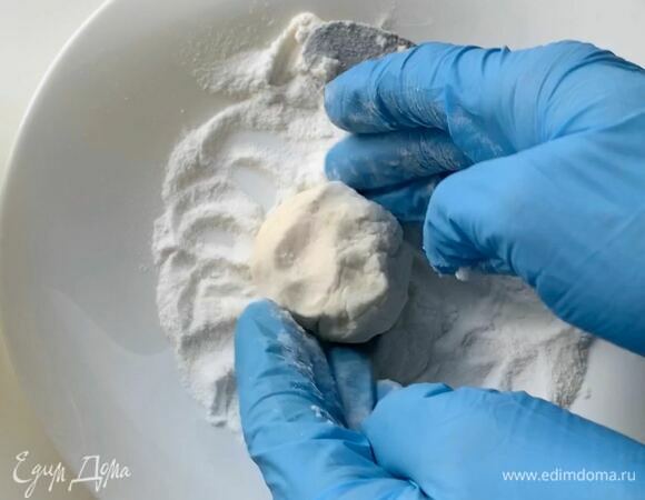 В отдельную плоскую тарелку положите 1 ст. л. рисовой муки, выложите ложкой тесто и сформируйте сырник.