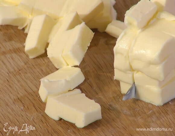 Предварительно охлажденное сливочное масло нарезать маленькими кубиками.