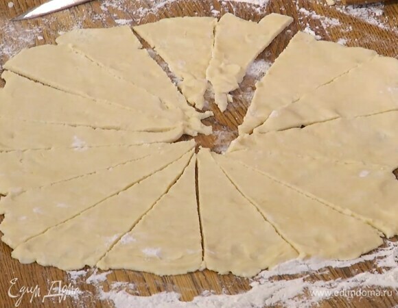 Половину теста выложить на рабочую поверхность, присыпанную оставшейся мукой, и раскатать в круг толщиной 3–4 мм, а затем разрезать на 16 секторов-треугольников.