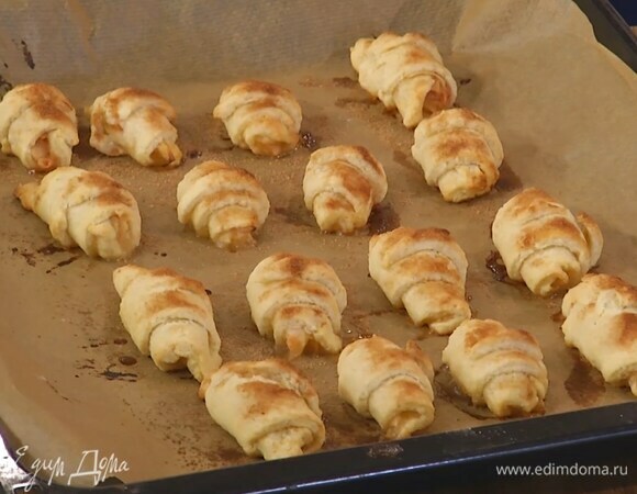 Выложить рогалики на противень, выстеленный бумагой для выпечки, посыпать корицей с сахаром и выпекать в разогретой духовке 12 минут.