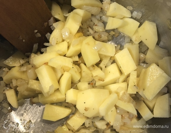 Перенести обжаренную смесь в кастрюлю, добавить нарезанный кубиками картофель, немного обжарить.
