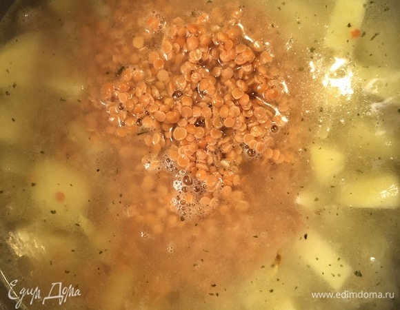 Следом влить овощной бульон или воду, всыпать заранее промытую чечевицу, довести до кипения.