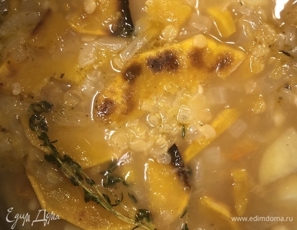 Добавить запеченную тыкву, веточку тимьяна и варить суп на среднем огне до готовности овощей и чечевицы.