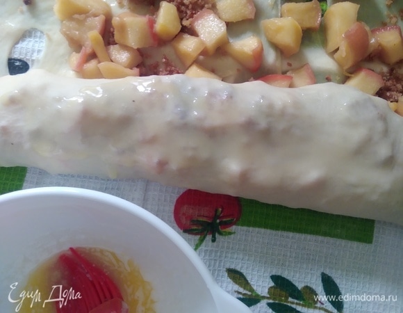 Начать сворачивать рулет с помощью полотенца, смазывая маслом.