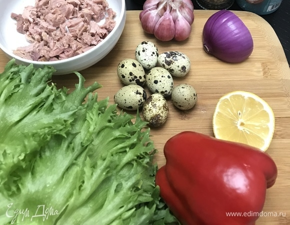 Филе тунца переложить из банки в глубокую тарелку, жидкость слить. Полить лимонным соком и оливковым маслом, дать постоять 20 минут. Яйца отварить, очистить и разрезать пополам. Листья салата промыть, просушить, крупные нарвать руками. Лук нарезать тонкими полукольцами. Сладкий перец — кубиком. Орешки прогреть на сухой сковороде.