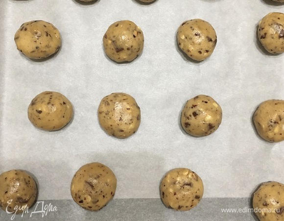 Скатать шарики из теста по 40–45 г. У меня вышло 18 штук. Выложить на противень с пергаментом.