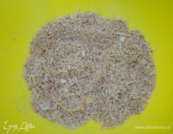 Духовку разогреть до 220°C. В миске смешать 50 г натертого на мелкой терке пармезана, панировочные сухари, мелко нарубленный чеснок. Куриные ноги разделить на две части в месте соединения костей (получится две голени и два бедра), посолить по вкусу и приправить черным молотым перцем. Яйцо взбить вилкой.