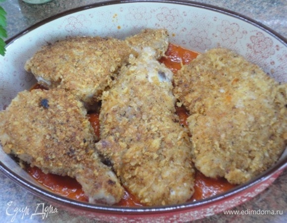 Половину томатного соуса выложить на дно формы для запекания, а сверху — кусочки курицы.