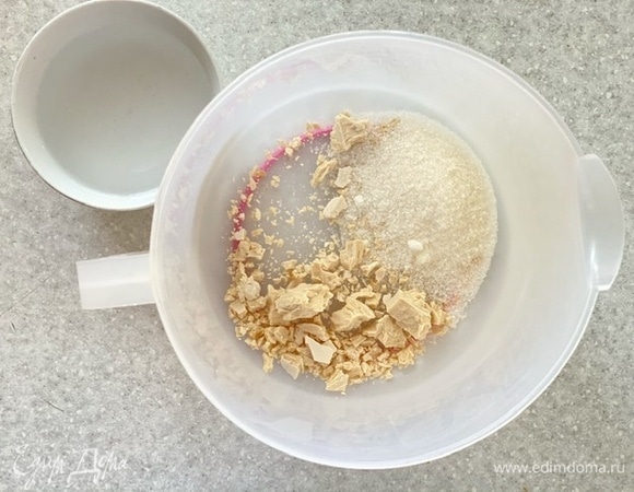 Дрожжи раскрошить в мерный стакан, добавить половину сахара и воду. Перемешать до растворения, оставить на 5–10 минут, до начала брожения.