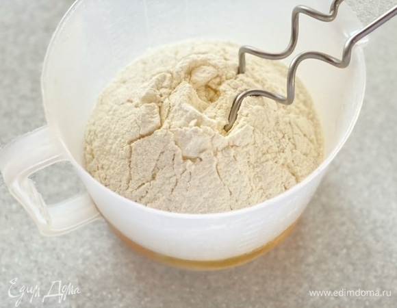 Добавить муку, соль и оставшийся сахар, перемешать крюком для замешивание теста 15 секунд. Увеличить скорость миксера.