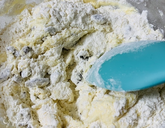 Добавляем изюм и просеянную муку. Перемешиваем миксером до однородности.