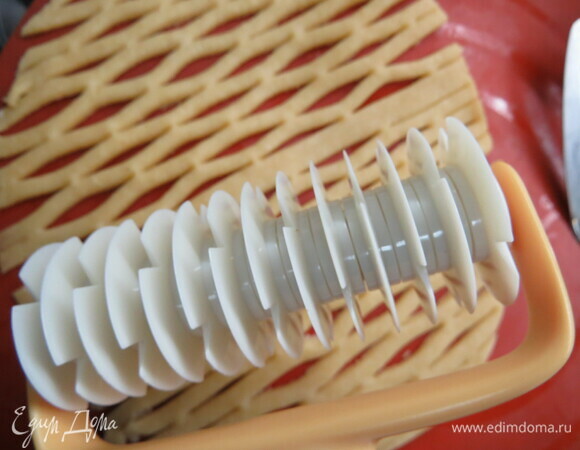 Формируем пирог. 2/3 теста раскатываем и выкладываем в форму, формируя бортики, на тесто выкладываем начинку. Вторая часть теста пойдет на формирование сеточки-решетки. Можно раскатать тесто и вырезать длинные полоски, выложить поверх пирога сеточкой. Или раскатать тесто и сделать ровные двух-трехсантиметровые надрезы так, как показано на фото, получится ажурная сеточка.