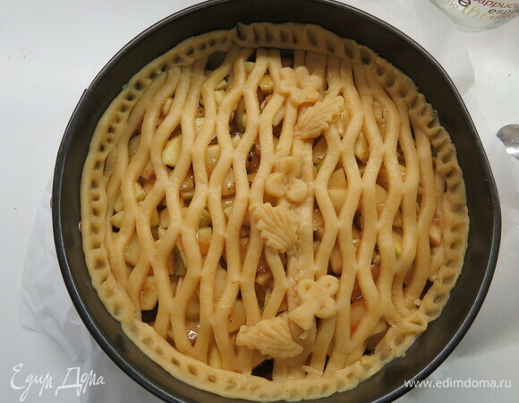 Аккуратно переносим сеточку-решетку на пирог, обрезаем лишние края по кругу. Из обрезков скатываем длинные жгутики и выкладываем их по краям формы, делаем насечки.