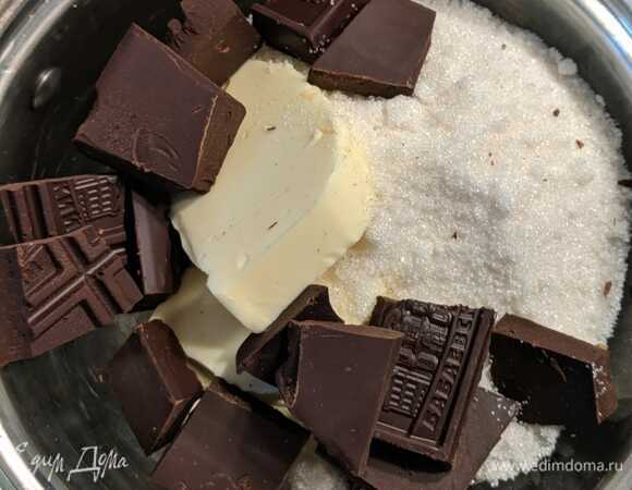 В стеклянную миску сложить сливочное масло, сахар и шоколад. Масло нарезать небольшим кубиком. Плитку шоколада разломать на кусочки.