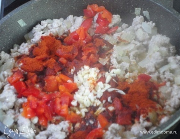 Теперь добавьте нарезанный кубиками болгарский перец, паприку и чеснок, хорошо перемешайте.