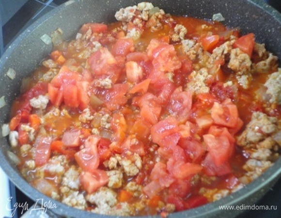 Через минуту добавьте помидоры, очищенные от кожицы и нарезанные кубиками. Еще раз хорошо перемешайте.