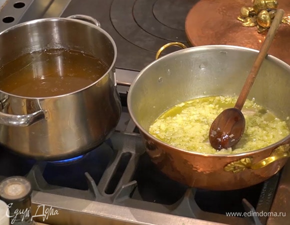 Разогреть в тяжелой, глубокой сковороде 1/2 ст. ложки сливочного и оливковое масло и слегка обжарить лук, затем добавить чеснок и на медленном огне готовить все до прозрачности.