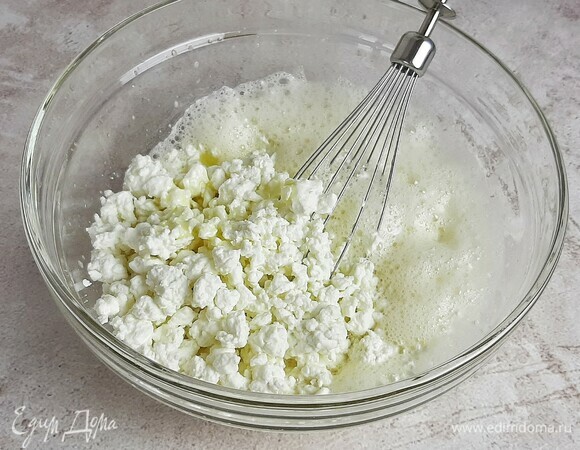 Добавляем растопленное сливочное масло (не горячее) и творог. Если творог крупный, можно пробить его блендером или протереть через сито.