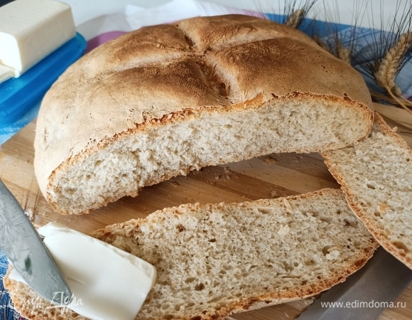 Нагреть духовку до 250°C. Затем уменьшить температуру до 230°C. На самую нижнюю полку поставить емкость с водой и выпекать хлеб в течение 20 минут. Затем снова уменьшить температуру до 180°C, убрать емкость с водой и выпекать хлеб еще 35 минут, приоткрыв дверь духовки, зафиксировав ее прихваткой так, чтобы был небольшой зазор — так образуется вкусная хрустящая корочка. Готовый хлеб можно хранить в бумажном пакете в течение 2–3 дней. Приятного аппетита!