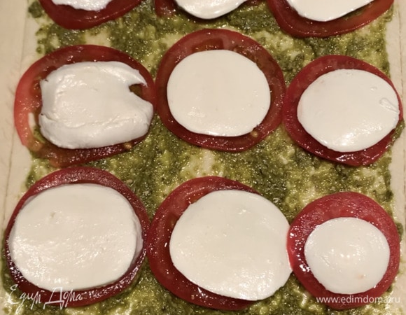 Сверху — нарезанную кружочками моцареллу. Посыпаем прованскими травами, края смазываем желтком. Отправляем в духовку, разогретую до 180°C, на 20–25 минут.