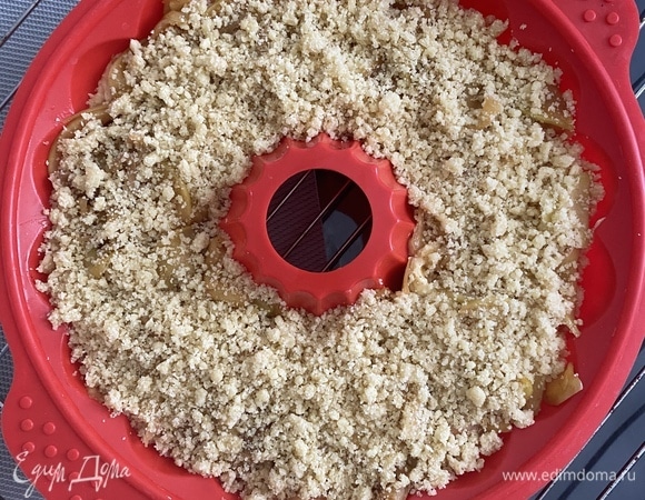 Сверху выложить яблочную начинку и засыпать крошкой.