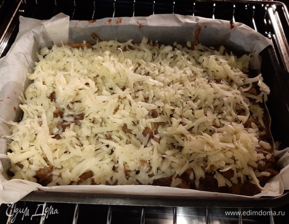 Через 20 минут достать, посыпать тертым сыром и поставить обратно еще на 10 минут.