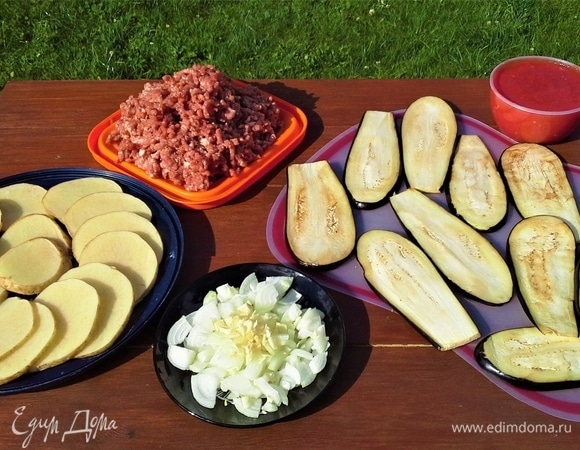 У баклажанов отрезать плодоножку. Нарезать вдоль длинными полосками толщиной 0,5 см. Лук почистить, некрупно нарезать. Чеснок почистить и измельчить. Картофель помыть, нарезать кружками. Мякоть мяса прокрутила через мясорубку. С помидоров сняла кожицу, взбила в блендере. В томатное пюре добавила кетчуп, можно томатную пасту.