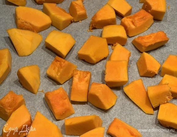 Нарезаем тыкву на кусочки и запекаем на пергаменте. Духовка — на 180°C, готовьте минут 30, если кусочки небольшие, как у меня.