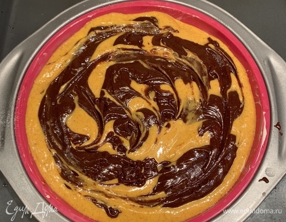 Откладываем 1/3 получившегося теста и смешиваем его с тыквенным пюре, растительным маслом и корицей. К оставшейся массе добавляем шоколадную смесь. Если добавляете орехи, отложите 4–5 ст. л. теста (для верхнего слоя), а в оставшееся добавьте мелко порубленные орехи. В форму выливаем большую часть теста (если добавляете орехи, то тесто с орехами), сверху — тыквенную смесь. Затем ложкой выкладываем оставшееся шоколадное тесто в произвольном порядке. Выпекаем в духовке, разогретой до 180°C, 40 минут.