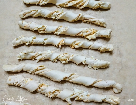 Полоски теста свернуть вдвое и соединить края теста. Скрутить жгутиком.