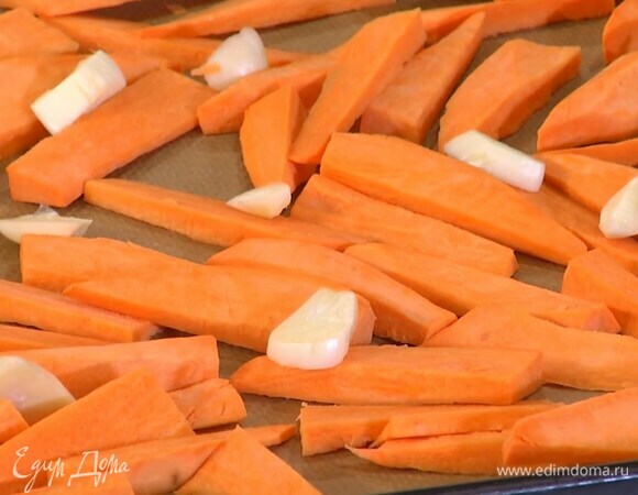 Чеснок почистить, крупно порезать и разложить на батат.