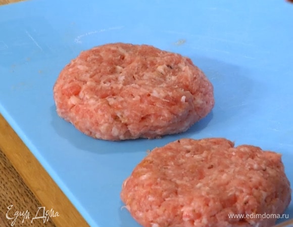 Фарш слегка посолить и поперчить, добавить щепотку паприки, натертый лук и все перемешать, затем слепить большие котлеты и дать им полежать 3–5 минут.